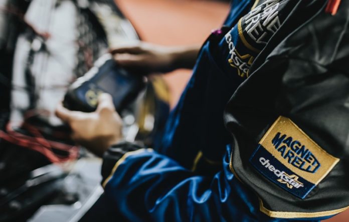 Meccanico con tuta da lavoro e logo NAPA durante un intervento