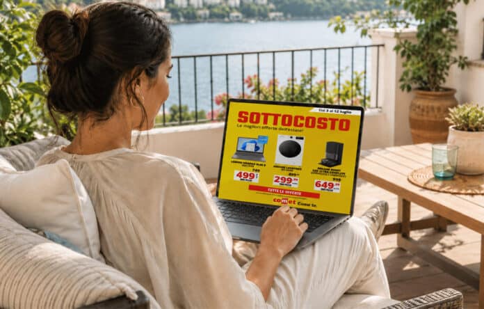 Donna seduta in terrazza consulta al computer il volantino Comet con offerte sottocosto