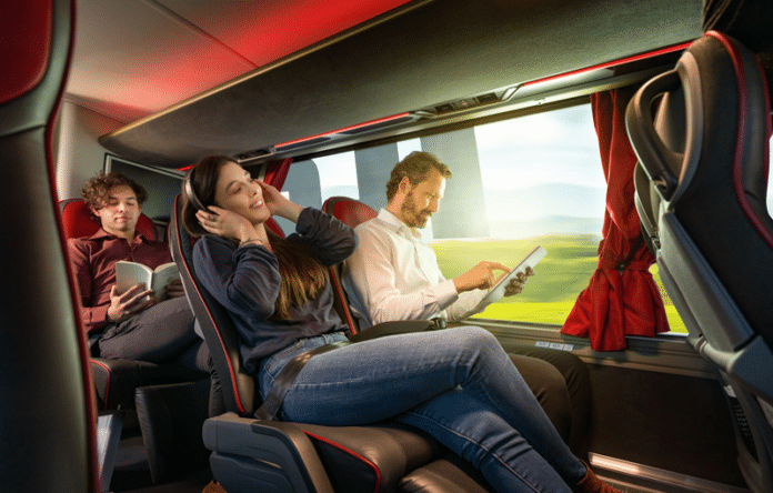 Passeggeri rilassati a bordo di un autobus moderno: musica, lettura e tablet durante il viaggio estivo