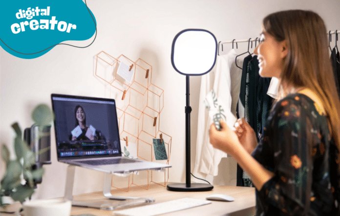 Creator che registra contenuti con ring light, pc e fotocamera