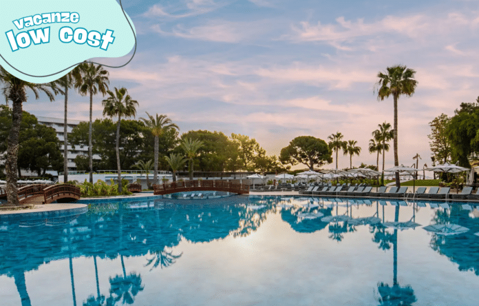 Resort con piscina e palme al tramonto per vacanza low cost
